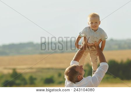 Father Playing With Son On Summer Weadow. Family Walking With Child Outdoor, Copyspace