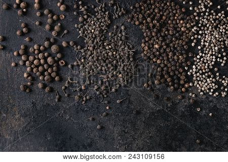 Variety Of Different Black Peppers Allspice, Pimento, Monks Pepper, Peppercorns Over Old Black Iron 