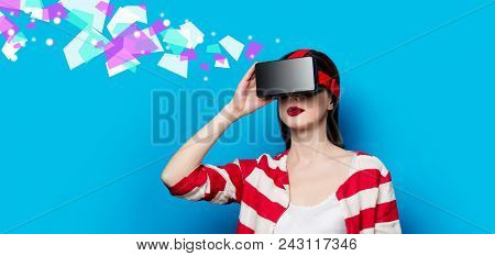 Portrait Of Beautiful Young Woman With Virtual Reality Gadget On Blue Background
