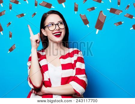 Portrait Of The Beautiful Young Smiling Woman On The Blue Background With Chocolade Ice-cream