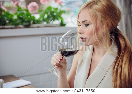 Leisure, Drinks, Degustation, People And Holidays Concept - Beauriful Blonde Woman Drinking Red Wine