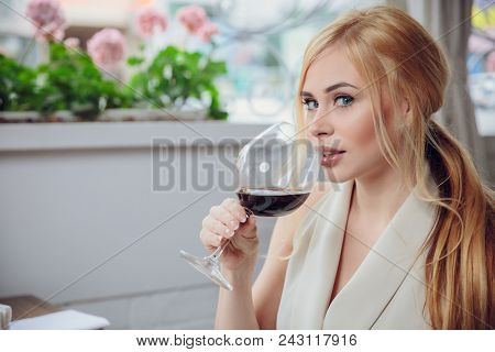 Leisure, Drinks, Degustation, People And Holidays Concept - Beauriful Blonde Woman Drinking Red Wine