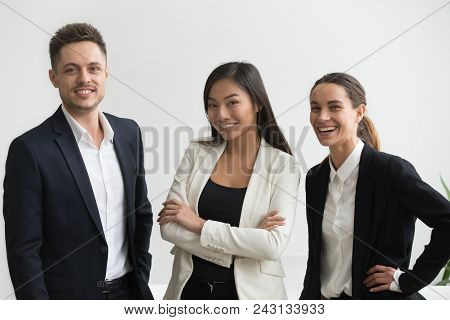 Millennial Smiling Multi-ethnic Professional Office Employees Looking At Camera, Asian And Caucasian