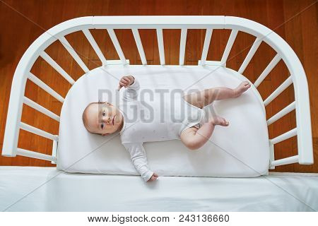 Baby Girl In Co-sleeper Attached To Parents' Bed