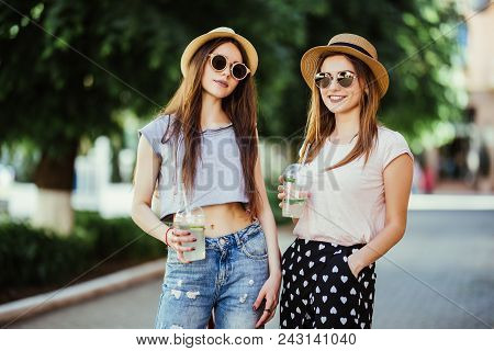 Happy Brightful Positive Moments Of Two Stylish Girls Hugging On Street In City. Closeup Portrait Fu