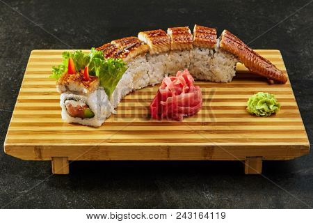 Kanada sushi rolls with salmon, eel, Philadelphia cheese, avocado and cucumber served on wood dish. Asian menu