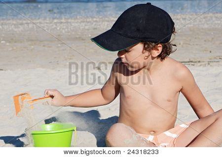adorable boy playing in the beach in summer