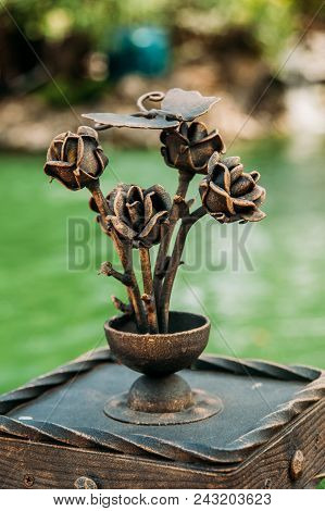Decorative Decoration Of A Metal With Forged Elements. Forged Roses In A Vase