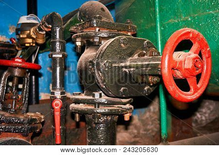 Several Old Painted Black With A Red Valve On The Cold Water Pipe.