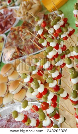 Many Skewers With Olives, Mozzarella Cheese Of Bufala, Mortadella And Red Tomatoes And A Lot Of Food