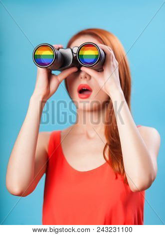 Redhead Girl With Binocular And Gey Flag On Blue Background.