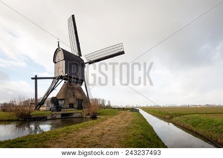 Picturesque Image Of A Dutch Wooden Hollow Post Mill As Seen From The Backside. The Mill, A Dutch Na