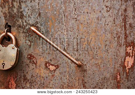 Old Dirty Rusty Metal Door With A Lock. Abstract Background.