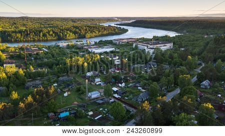Bird's eye view of houses in urban-type settlement Nikolskiy, Svir river and summer green forests of Leningrad region, Russia.