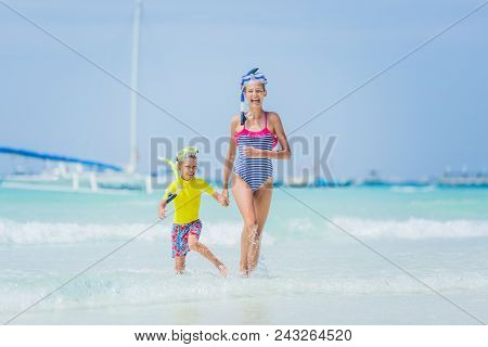 Brother And Sister Playing And Having Fun On The Beach During The Hot Summer Vacation Day.