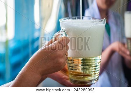 Pouring Sparkling Wine In Glass Jug At Winery.