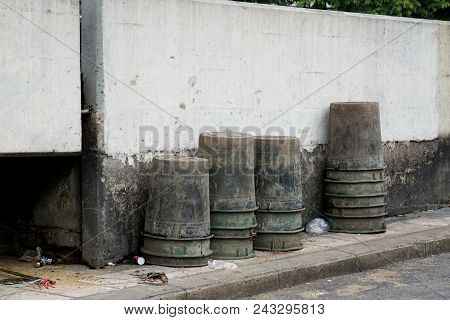 Stack Of Old Black Plastic Container Use To Keep Gabage Place Beside Street.