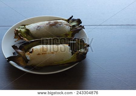 A Plate Of Two Delicious Grilled Sticky Rice Toast Filled With Banana And Taro Wrapped In Banana Lea
