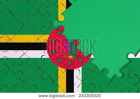 Dominica Flag  Is Depicted On A Completed Jigsaw Puzzle With Free Green Copy Space On The Right Side