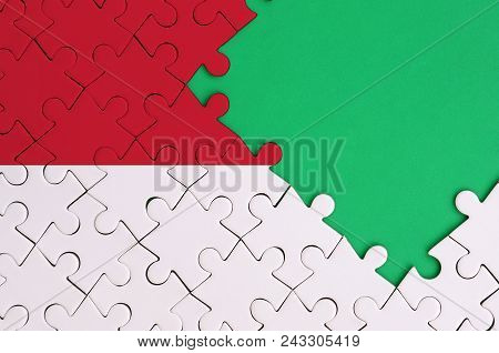 Indonesia Flag  Is Depicted On A Completed Jigsaw Puzzle With Free Green Copy Space On The Right Sid