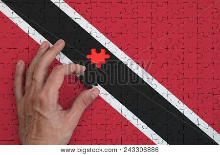 Trinidad And Tobago Flag  Is Depicted On A Puzzle, Which The Man's Hand Completes To Fold