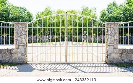 Chrome Fence Gate. Chromium Stainless Steel Fence On Stone Wall