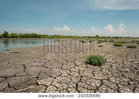 Land With Dry And Cracked Ground And The Grass-awaited Growth Neary River Because The World Warms Up
