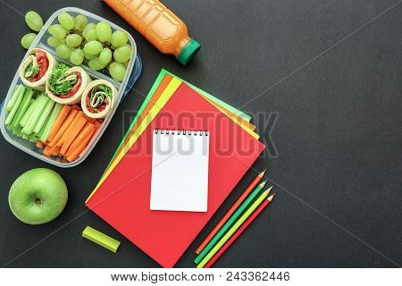 School Supplies And Lunch Box With Tasty Rolls, Cucumbers, Carrots, Grapes, Apple, Bottle Of Juice O