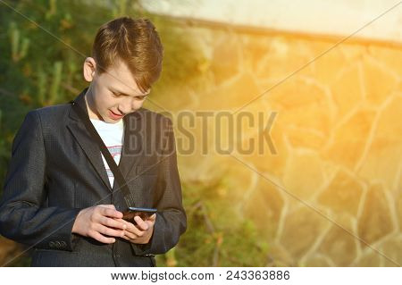 A Boy With A Smartphone Reads A Message In A Smartphone
