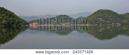 Hills Covered By Green Forest Reflecting In Lake Begnas, Nepal.