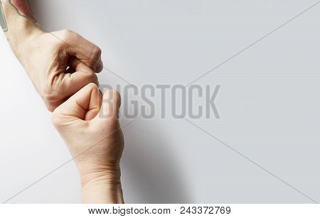 Close Up Clash Of Two Fists On White Blank Background. Concept Of Confrontation, Competition Etc