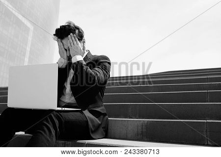 Young Confidental Businessman Wearing Suit And Using Modern Laptop Outdoors. Successful Banker Worki