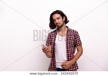 Wel-built Guy In Red Checkered Shirt. Holding Smartphone.