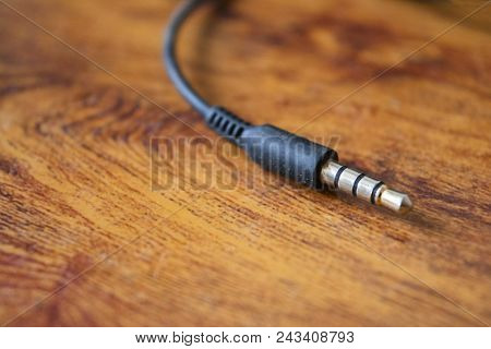 Earphone Jack On Abstract Wooden Table Background