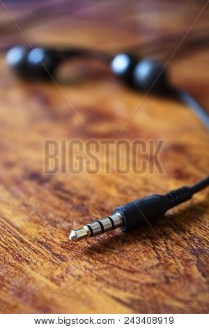 Earphone Jack On Abstract Wooden Table Background