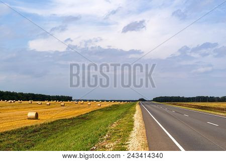 Landscape Of The Agricultural Field After Harvesting Of Cereals With Sheaf Of Straw And The Highway