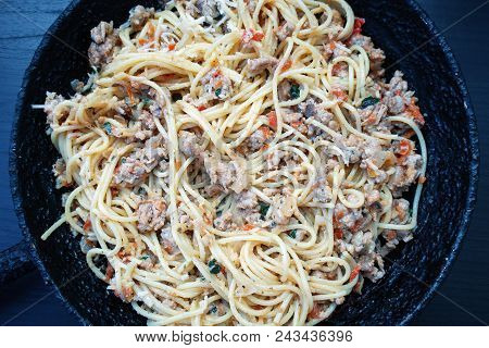 Appetizing Spaghetti In An Old Frying Pan With Bolognese Sauce On A Dark Background Close Up