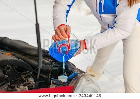Woman In Ski Jacket Pouring Antifreeze Car Screen Wash Liquid Into Dirty Car From Blue Anti Freeze W