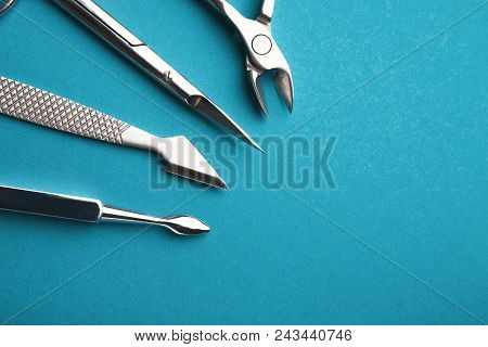 Manicure And Pedicure Beauty Accessories On Blue Background, Copy Space. Cutice Cutter And Pushers, 