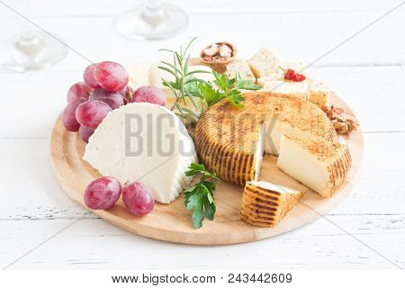 Cheese Platter With Assorted Cheeses, Grapes, Nuts Over White Wooden Background, Copy Space. Italian