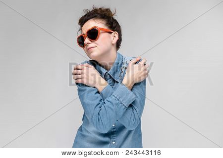 Young Girl With Glasses In Heart On Gray Background. Portrait Of A Young Beautiful Girl. Charming Gi