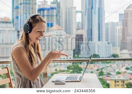 Young Woman Teaches A Foreign Language Or Learns A Foreign Language On The Internet On Her Balcony A
