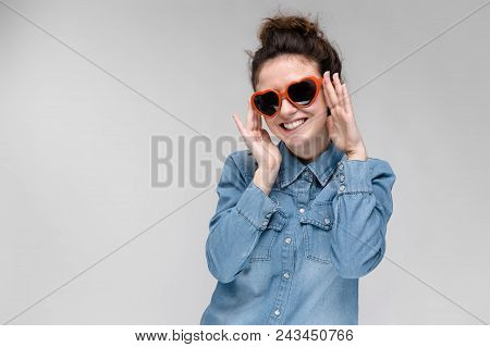 Young Girl With Glasses In Heart On Gray Background. Portrait Of A Young Beautiful Girl. Charming Gi