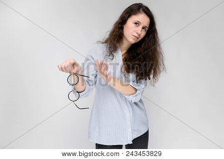 Happy Young Girl In A Light Blouse And Dark Pants. The Girl Refuses To Take Glasses.