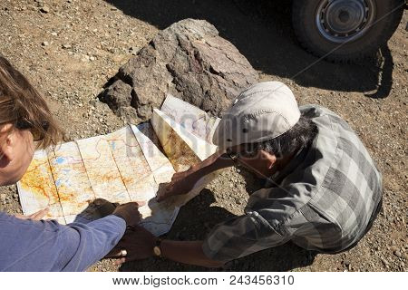 Gobi Desert-august 6, 2010. Women And A Man Looking At A Map Of The Gobi Deser, Mongoliat To Continu