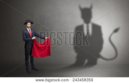 Businessman standing with red cloth in his hand and devil shadow on the background