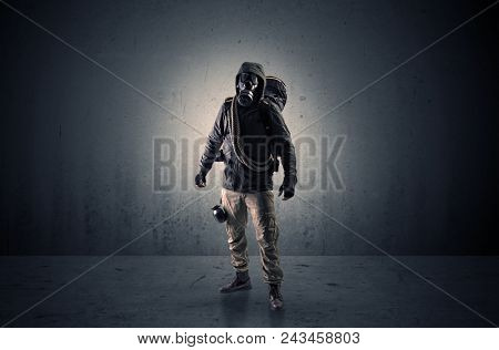 Bad agent in a dark room with arms on his hand and gas mask