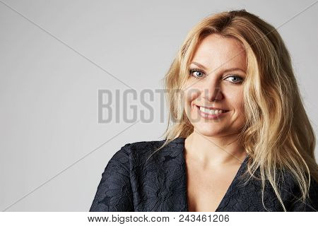 Fashion Photo Of A Beautiful Blonde Woman In A Pretty Dress Posing Over Gray Empty Background. Fashi