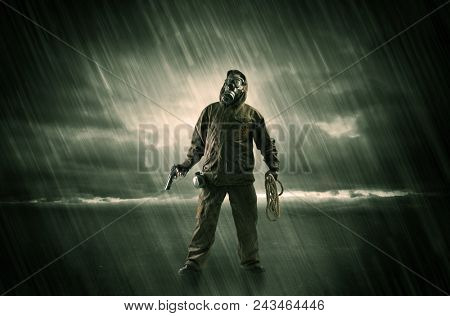 Terrorist in a stormy space with gas mask on his hand and weapons on his arm