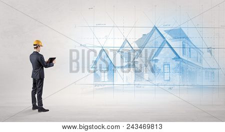 Architect standing and watching an imagined house plan